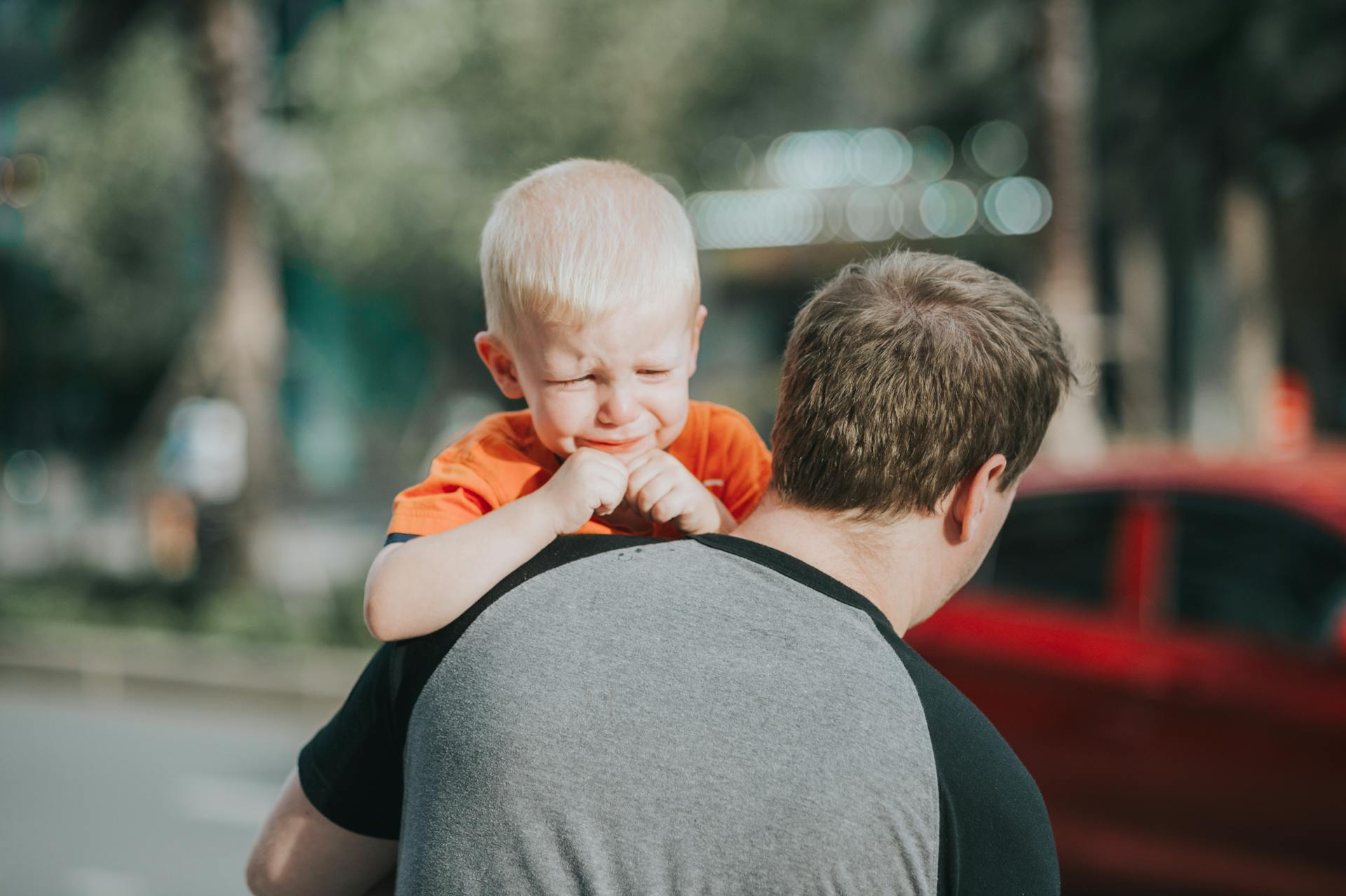 a man carrying a crying child