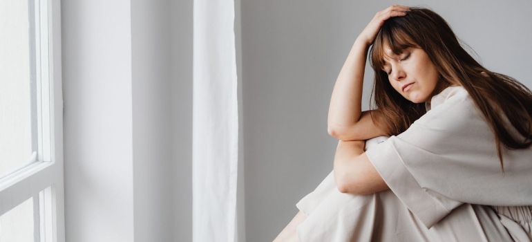 a girl sitting in bed with her eyes closed 