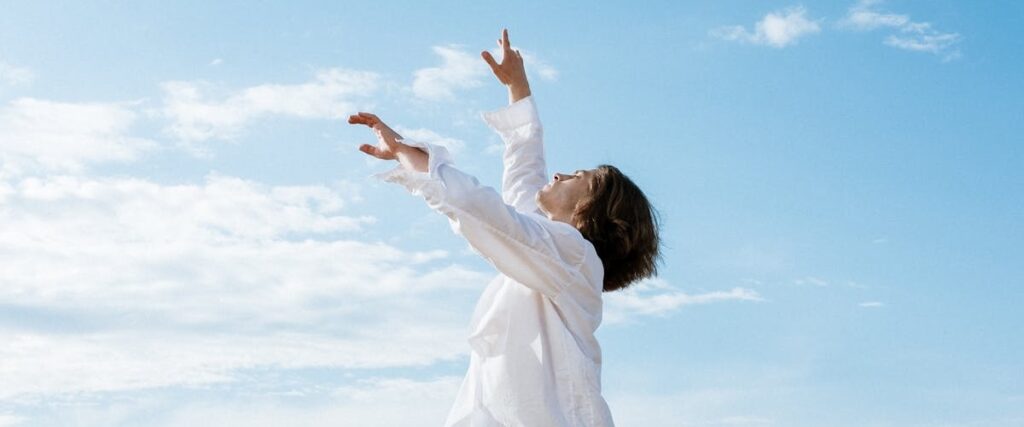A person raising their hands and looking at the sky, feeling free after finishing a rehab Richmond VA program