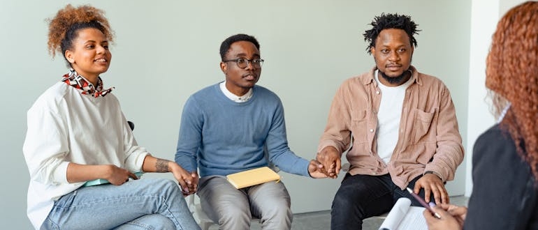 People talking and holding hands during a group therapy program Virginia residents recommend