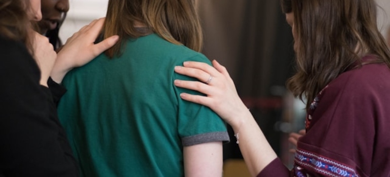 A group of people hugging a woman